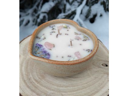 Dekorační svíčka s minerály a jemnými kvítky v misce z kameniny ve tvaru srdce.