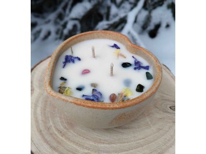 Dekorační svíčka s minerály a jemnými kvítky v misce z kameniny ve tvaru srdce.