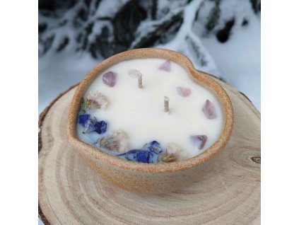 Dekorační svíčka s minerály a jemnými kvítky v misce z kameniny ve tvaru srdce.