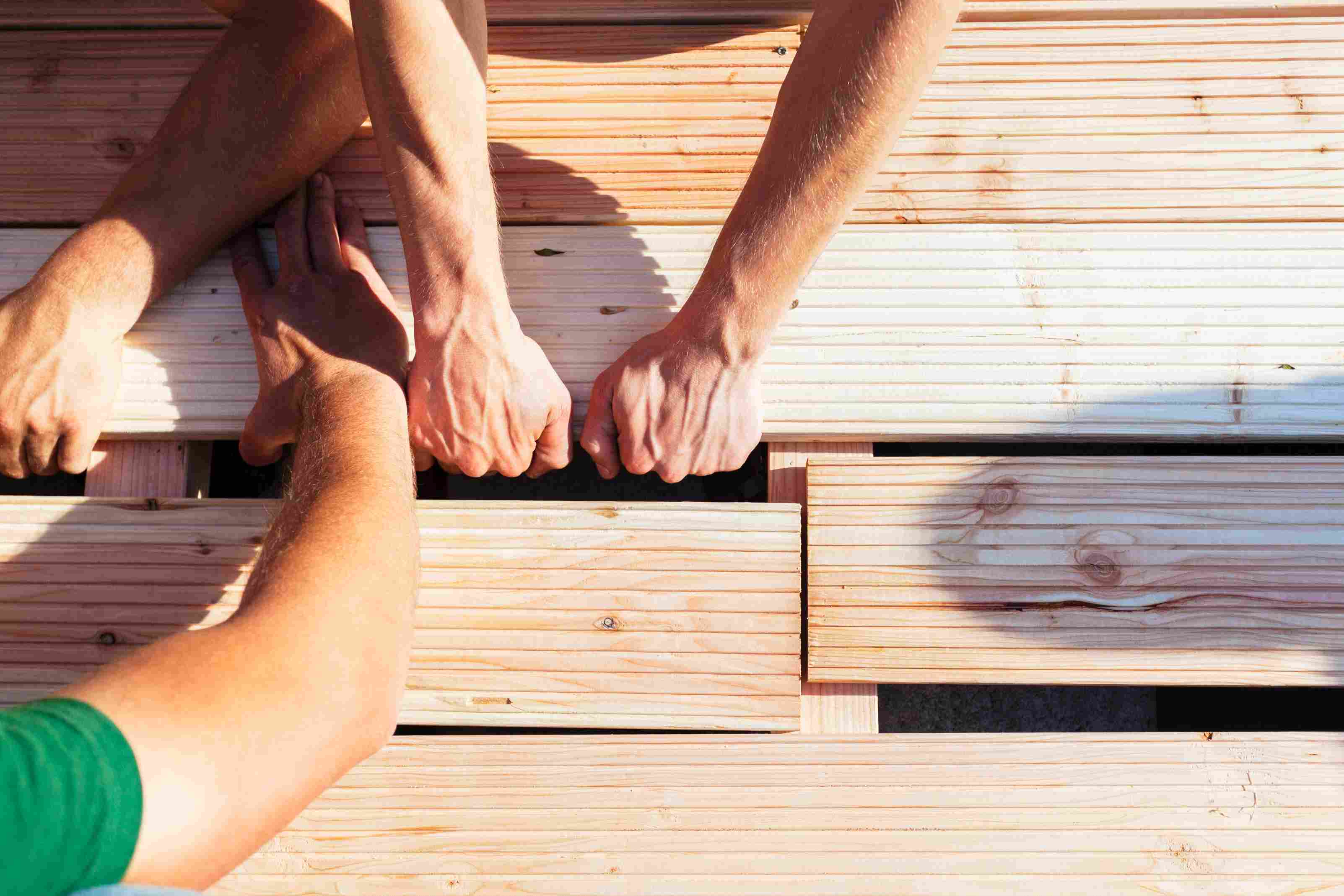 detailna-ukazka-vymeny-terasovych-dosiek-za-nove-ruky-troch-ludi-kde-kazdy-poklada-novu-dosku