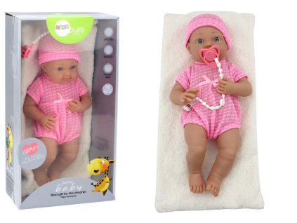 Baby doll in pink clothes, hat, pacifier, and blanket
