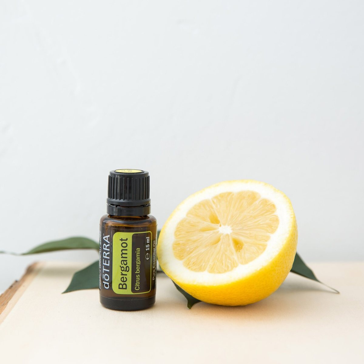 Bergamotový esenciálny olej doTERRA vedľa rozkrojeného citrusu