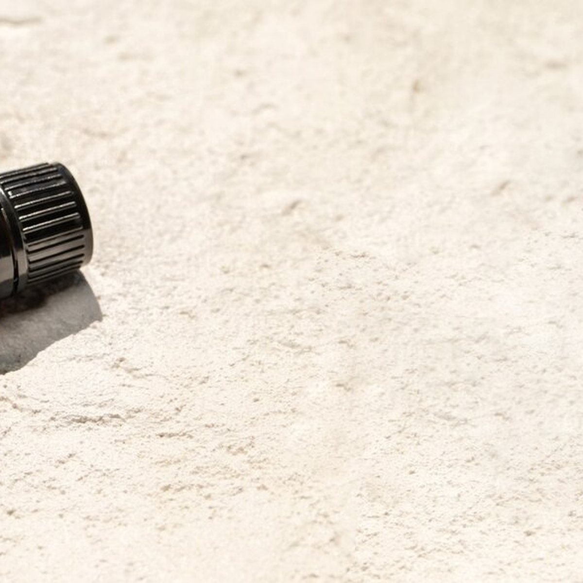 doTERRA Black Spruce ležiaci na svetlom piesku