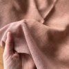 Řídce tkané zemitě narůžovělé plátno, vyšisované okraje