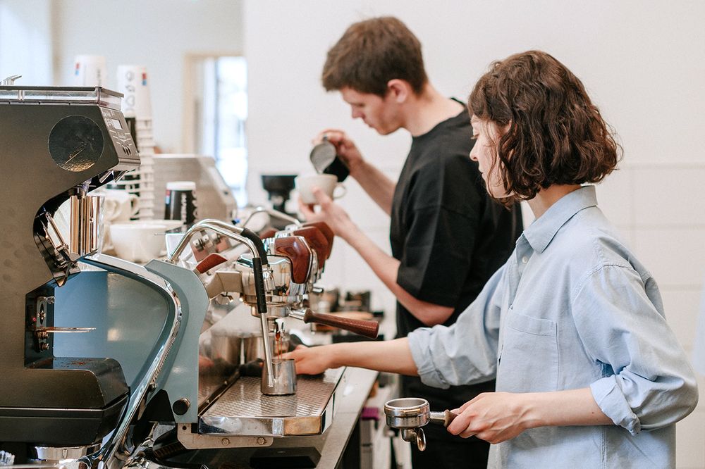 Two barista working behind the bar Two barista working behind the bar