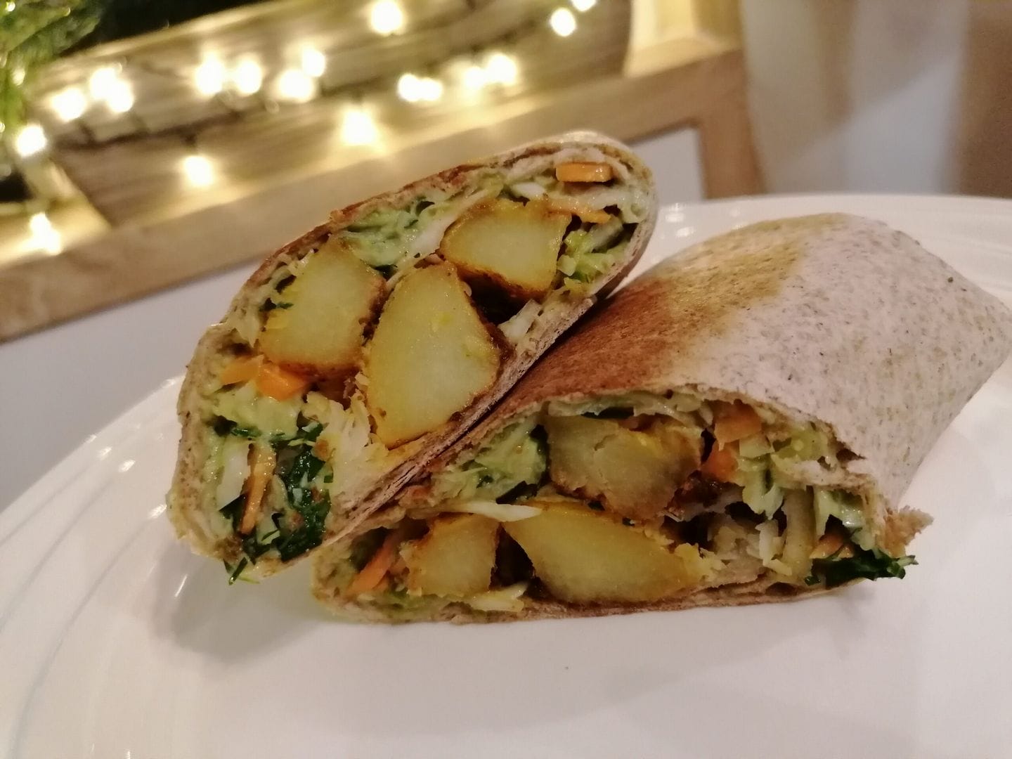 Tortilla plněná pečenými kari brambory, salátem a avokádovým dipem