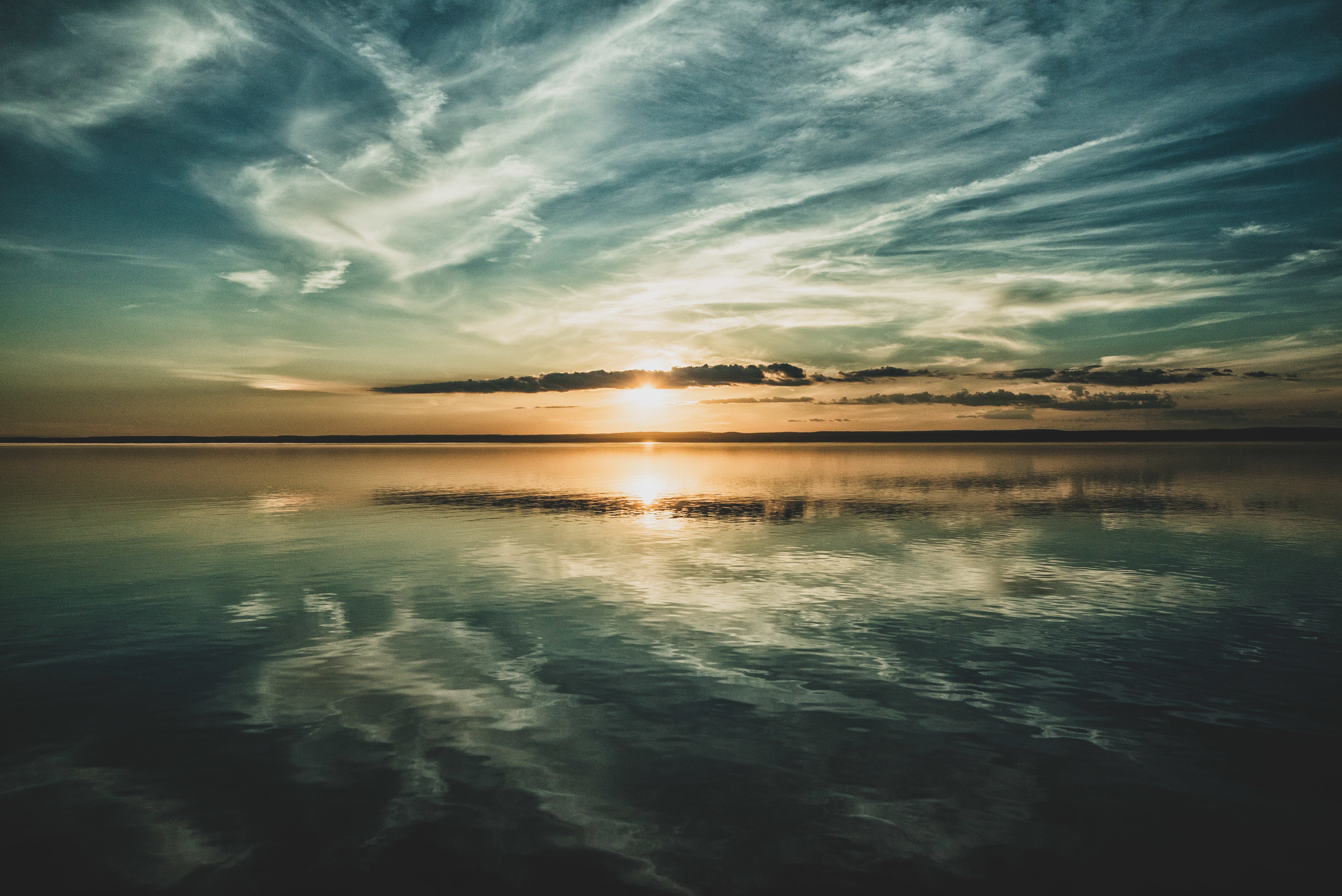 setting-sun-clouds-sky-reflected-ocean