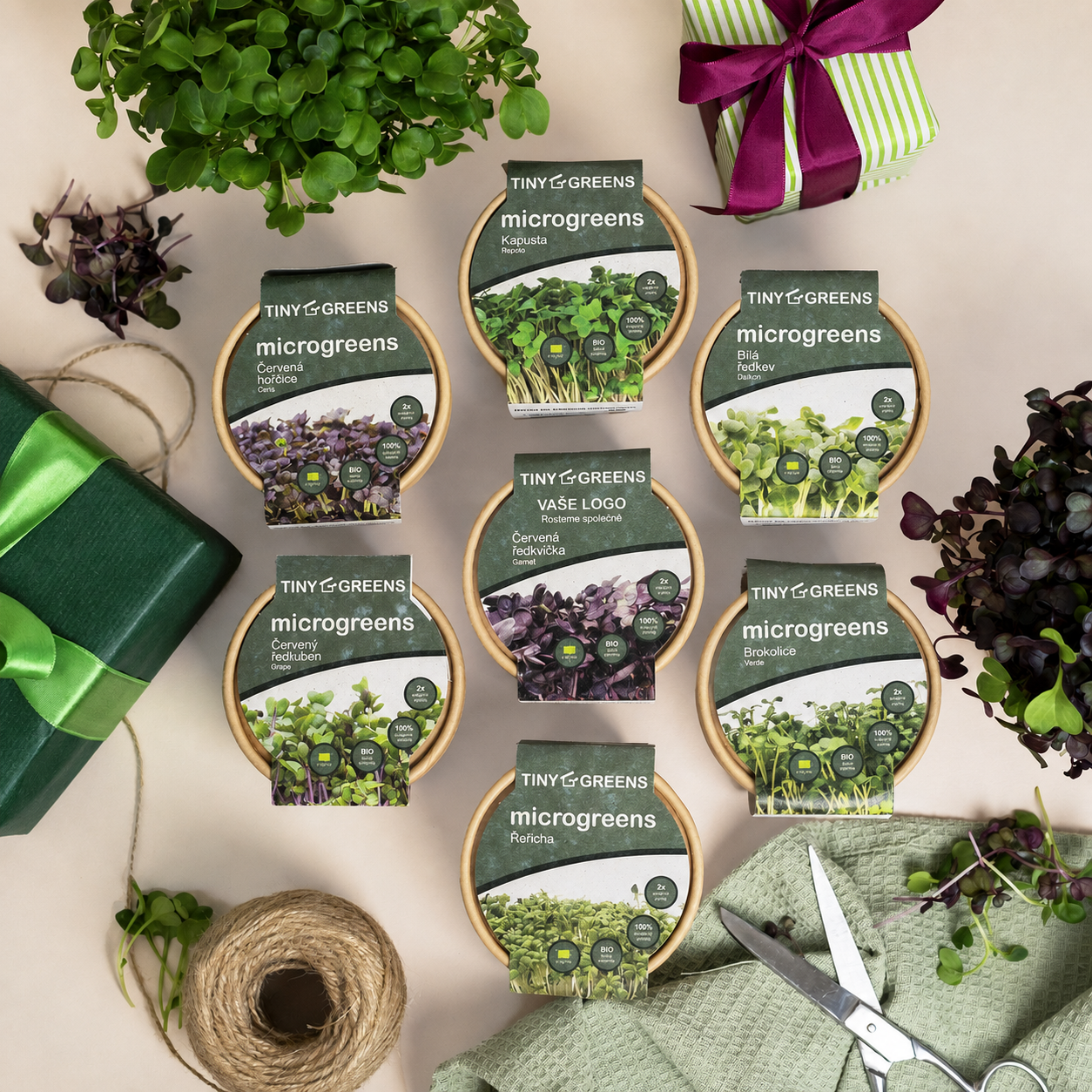 Pěstební kelímky Tiny Greens s různými druhy microgreens a ukázkou firemního loga