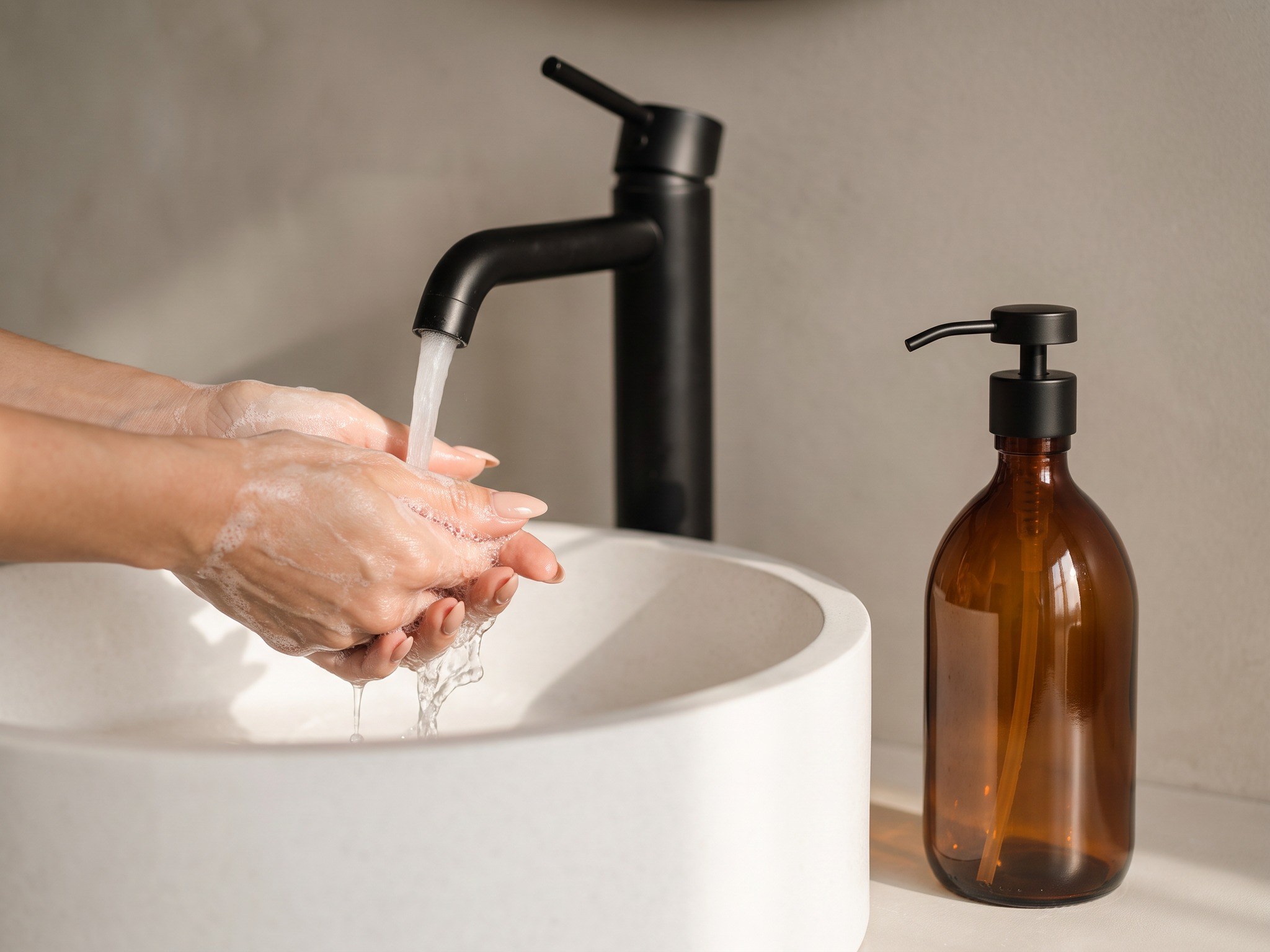 Hnědý skleněný dávkovač na mýdlo s černou kovovou pumpičkou