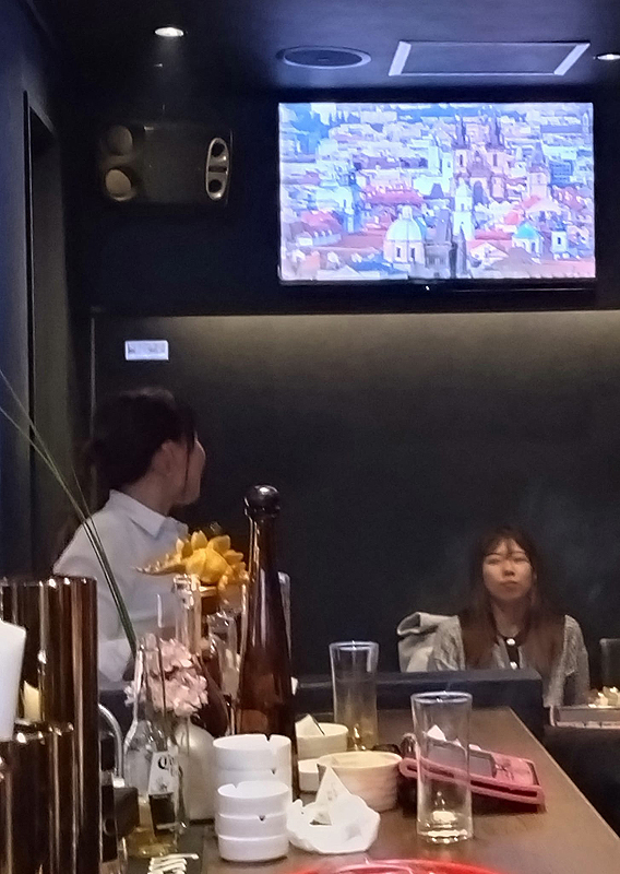 Staré město pražské na obrazovce v japonském nočním baru. 