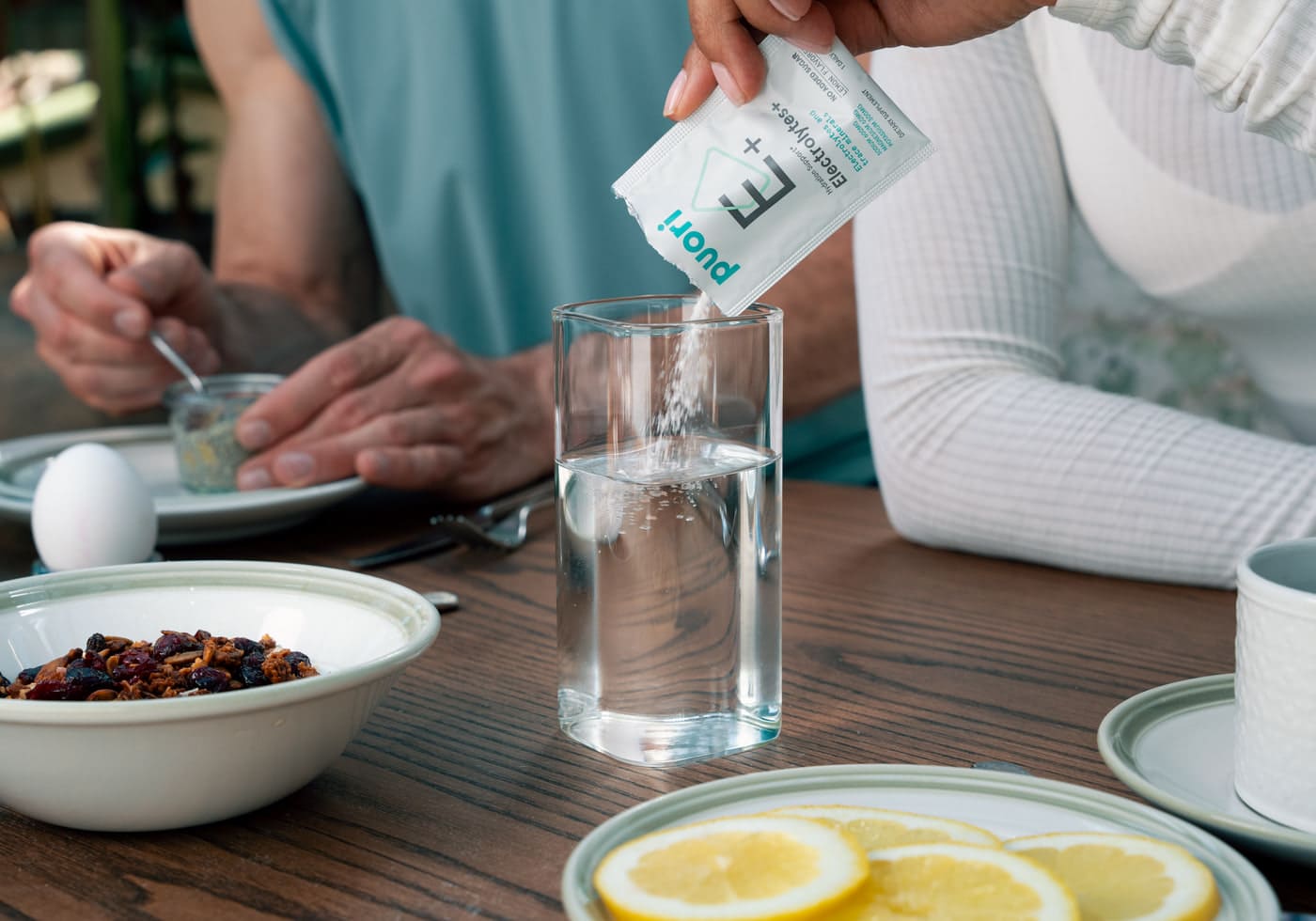 Sypanie Puori Electrolytes+ z vrecúška do pohára vody