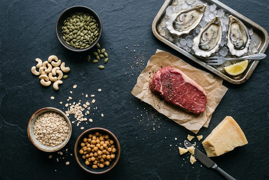 Ustrice, hovädzí steak, tekvicové semienka, kešu, ovsené vločky, cícer a tvrdý syr na tmavej doske