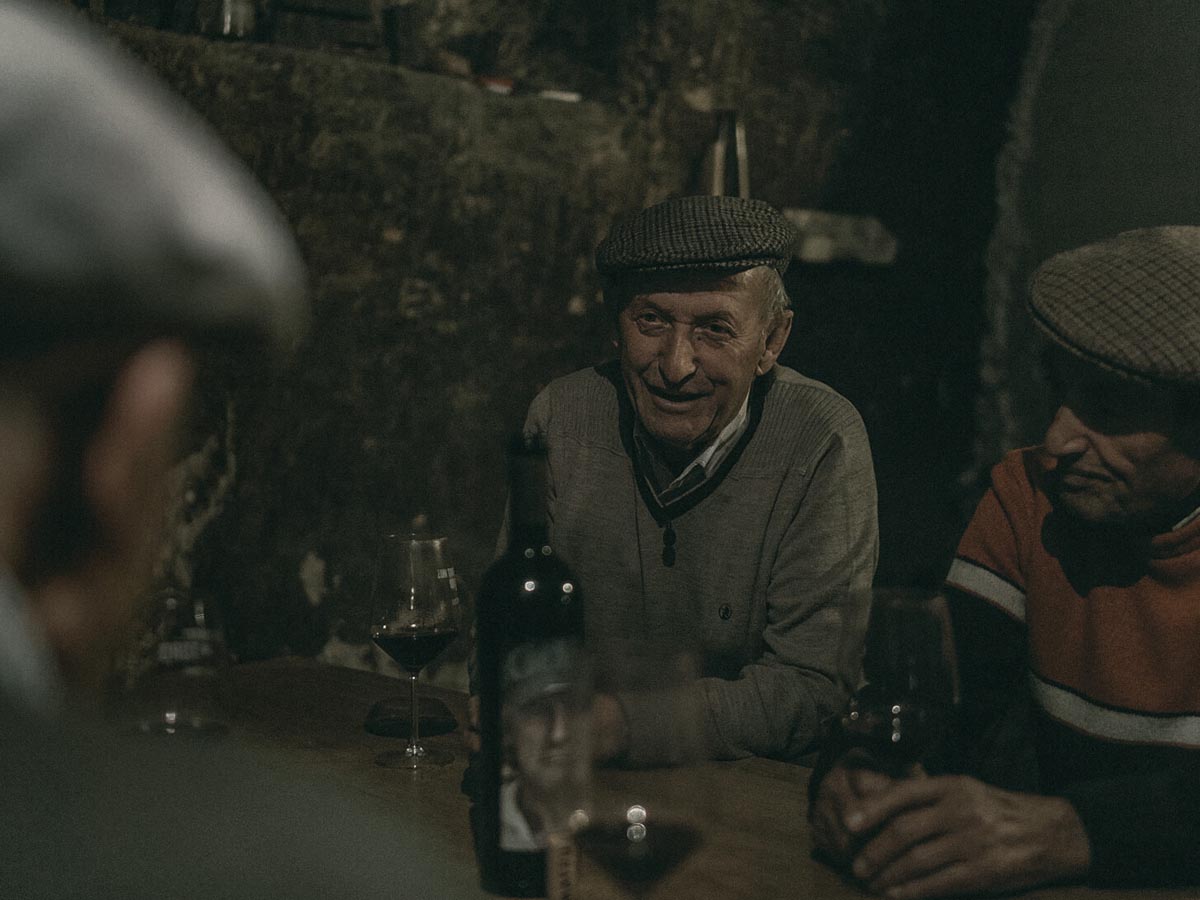 Vinohradníci z Tora pri stole s pohármi vína