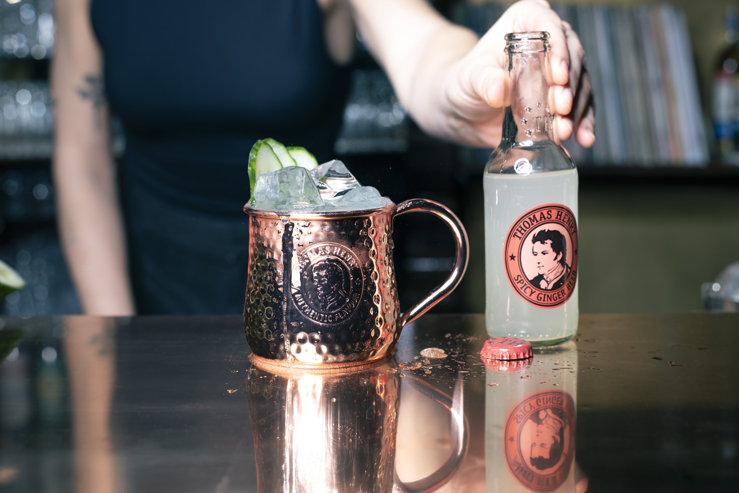 Barman dolévá Moscow Mule v měděném hrnku