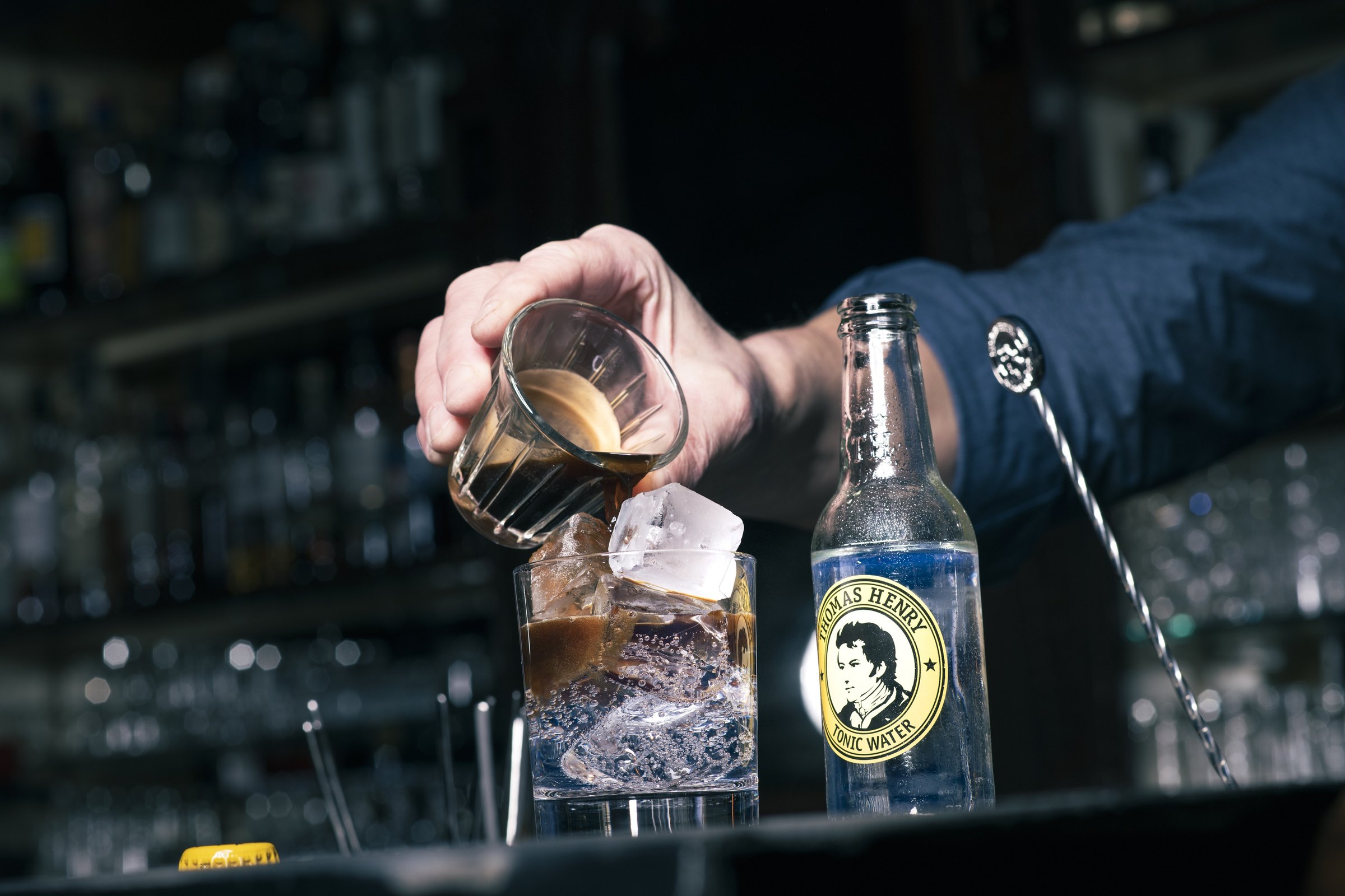 Barman lije espresso do sklenice s tonikem a ledem