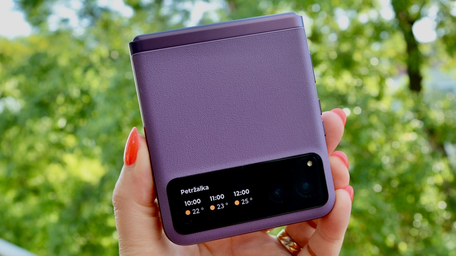 Sklopený fialový telefón Motorola Raz 40 v ruke. 