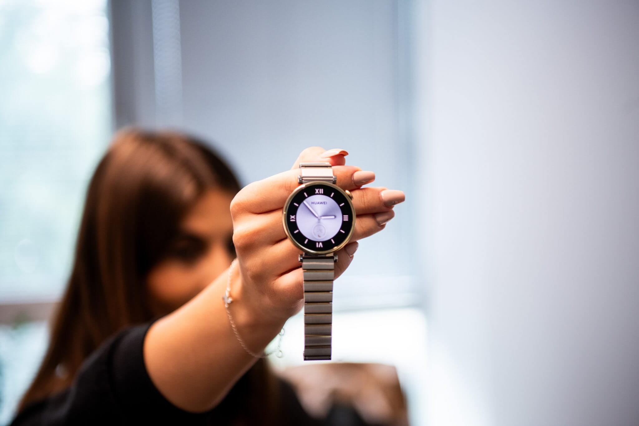 Žena, držiaca dámsku verziu hodiniek Huawei watch 4 series.