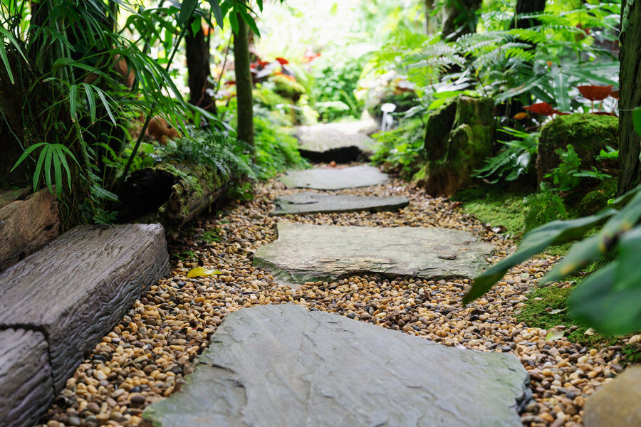 Záhradný chodník s veľkými kameňmi s  štrkom. 