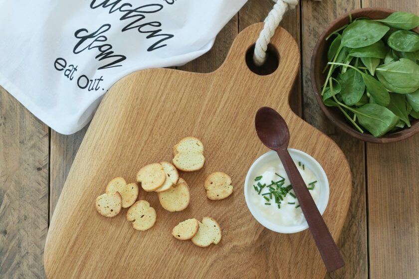 Doska na krájanie, na ktorej je pomazánka a chlieb.