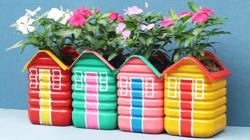 Ručne vyrábané plastové kvetináče v podobe farebných domčekov.