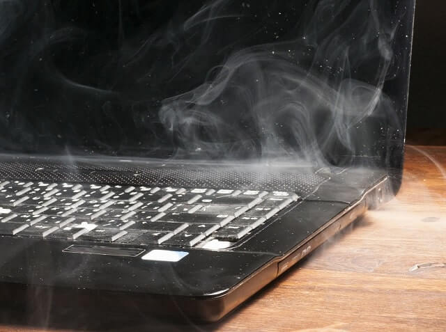 Čierny notebook, s ktorého vychádza dym. 