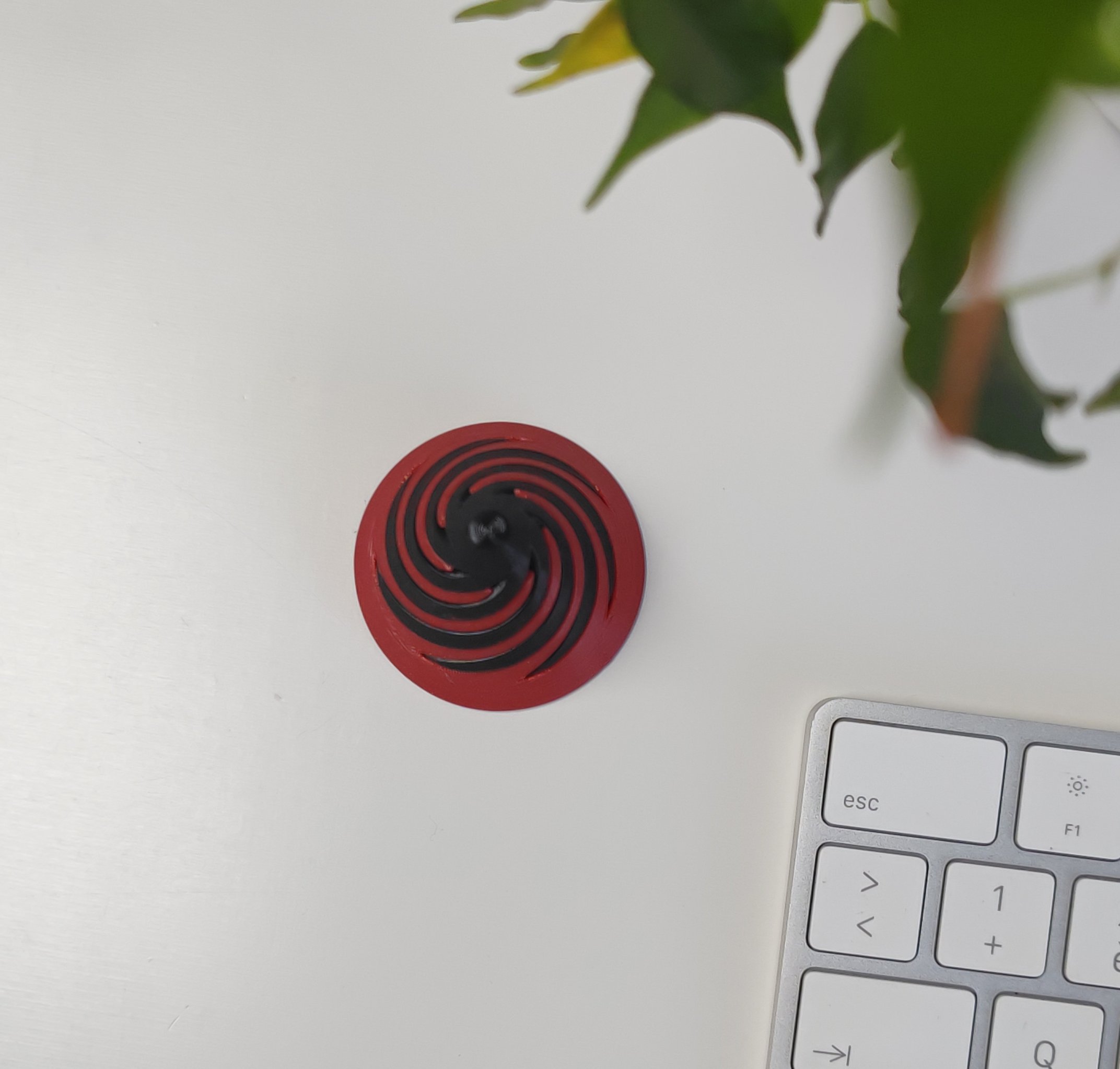 TwistCone | Dekorativní fidget na stole vedle klávesnice.