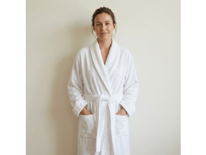 standing woman wearing white frote terry bathrobe shawl style, wjth the background of creamy white wall @White terry bathrobe