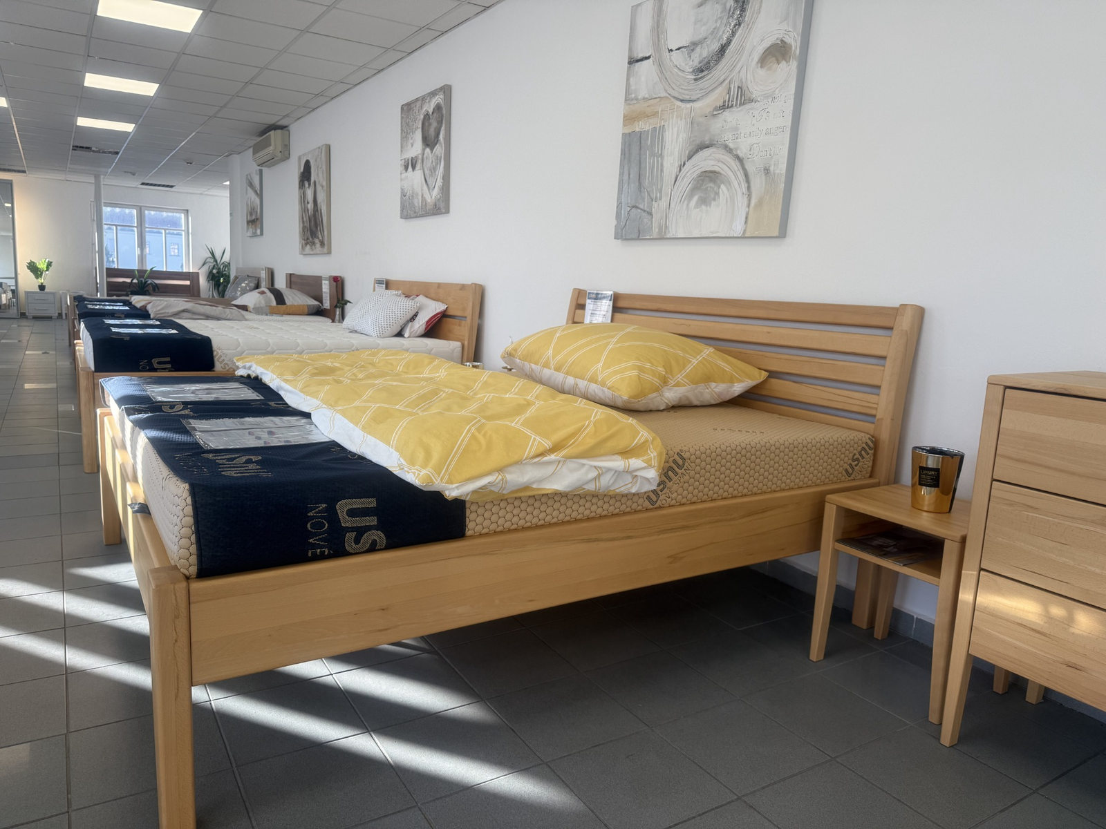 Dřevěná manželská postel z masivu vystavená v showroomu USNU Frýdek-Místek