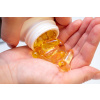 yellow omega 3 fish oil pills hand
