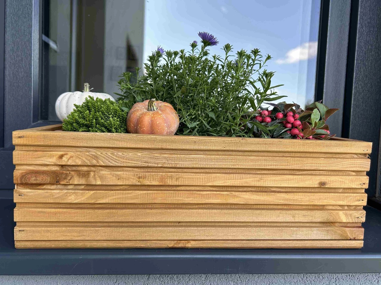 Dřevěný truhlík s podzimní výsadbou na balkoně
