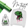 Matná zelená nažehlovací fólie na textil – role s pohledem na strukturu a povrch, ukázka aplikace na bílou mikinu s potiskem dinosaura a nápisem „Rexík“ a na bílý batoh s motivem zelené žabičky a nápisem „Kukuč“.