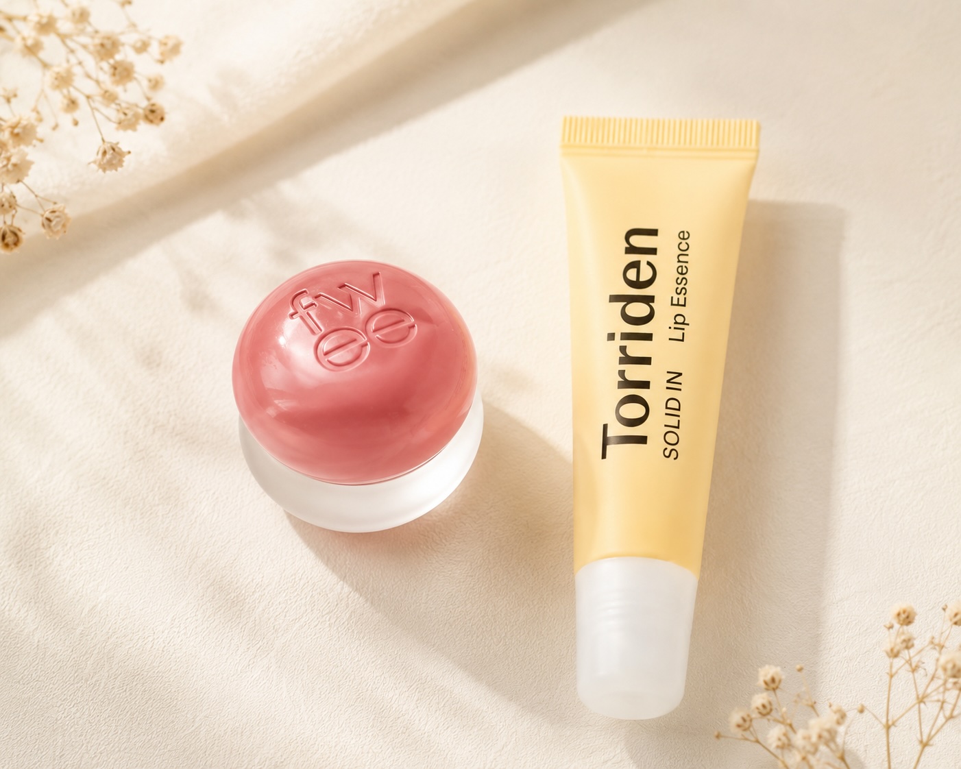 Tónovaný balzám FWEE Lip & Cheek Blurry Pudding Pot vedle lip essence Torriden Solid-in Lip Essence, flatlay péče o rty