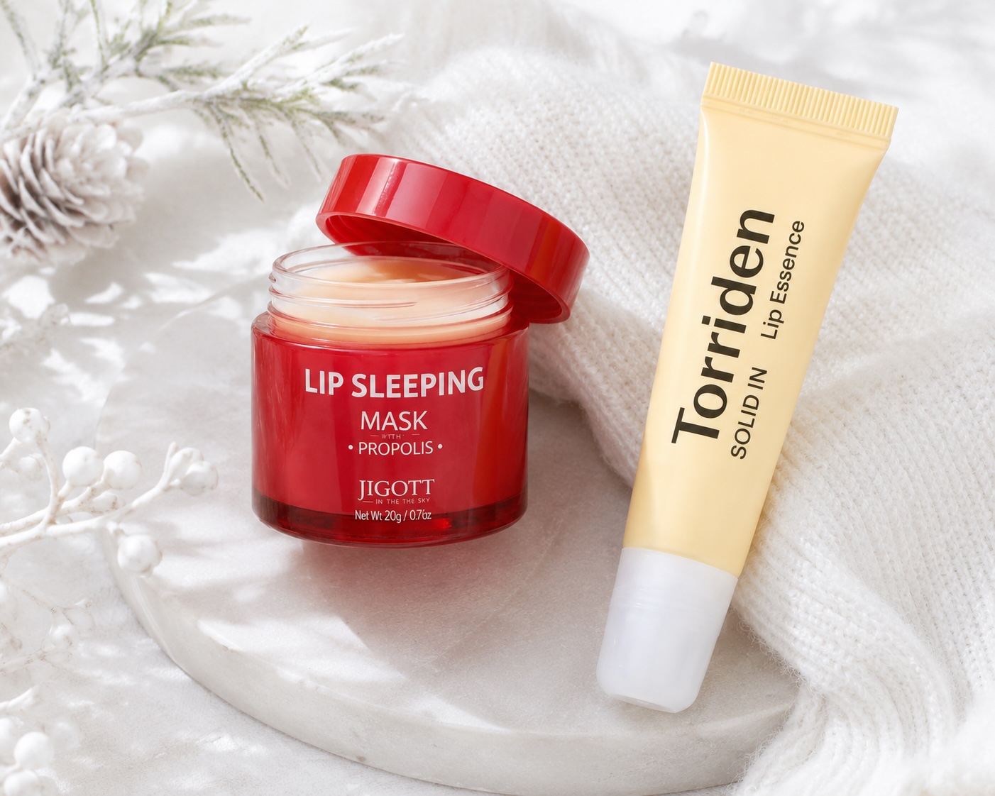 Zimní péče o rty – Jigott Lip Sleeping Mask Propolis a Torriden Solid-in Lip Essence, flatlay