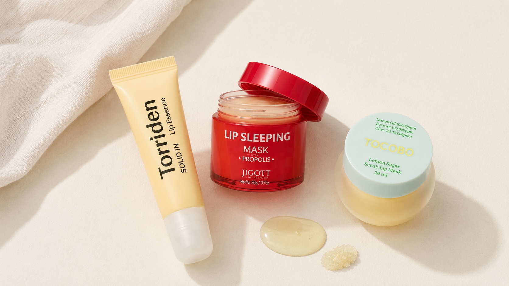 Flatlay produktů na péči o rty – lip essence, noční maska a scrub maska na rty