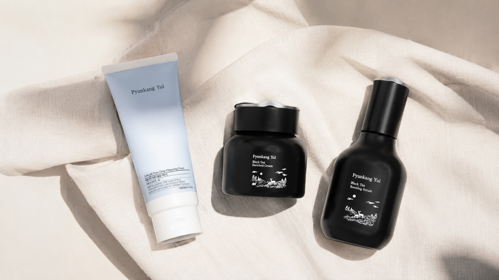 Flatlay produktů Pyunkang Yul pro citlivou pleť – čisticí pěna, bariérový krém a Black Tea péče