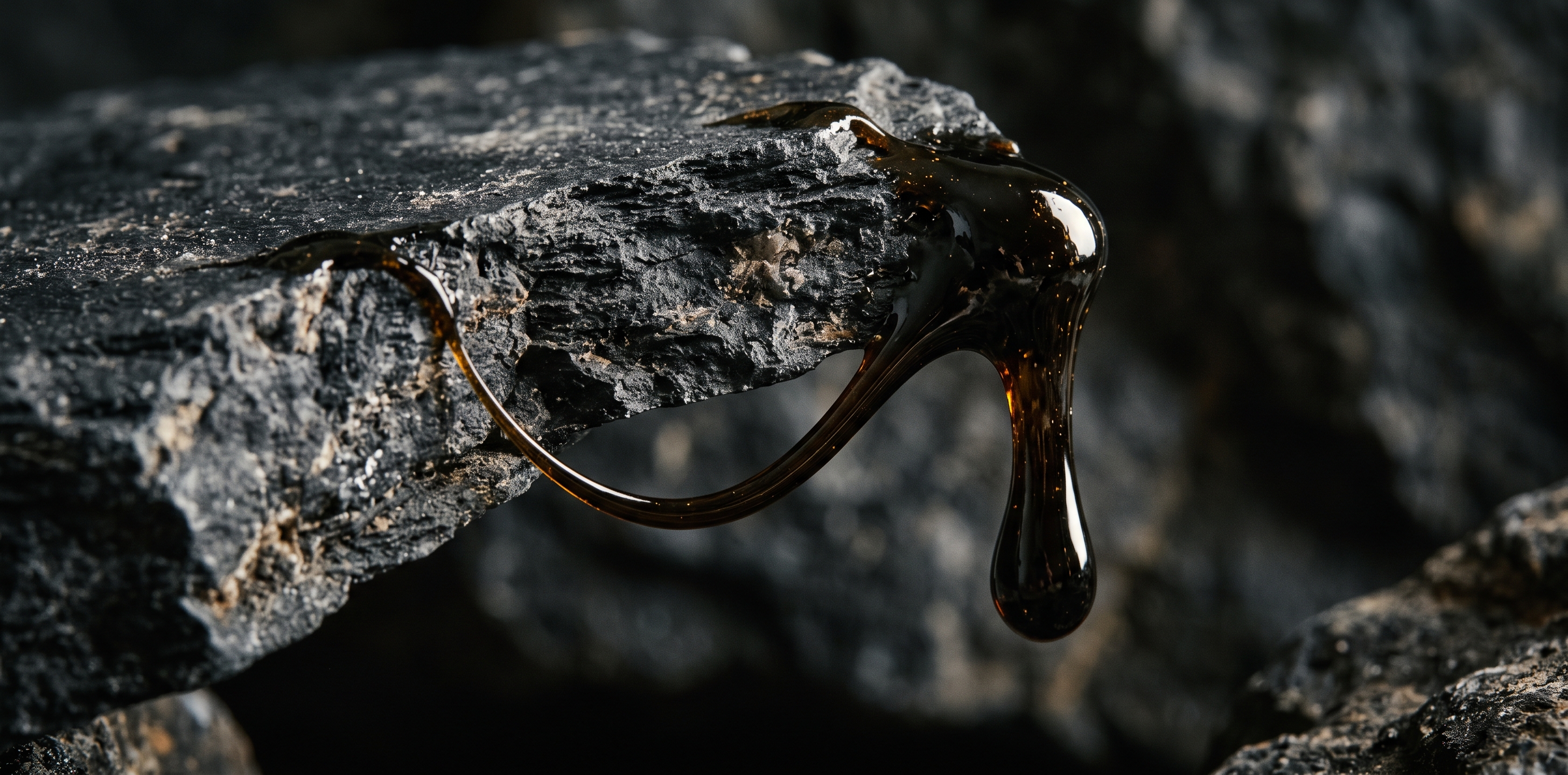 Čistý shilajit mumio – kapka minerální pryskyřice na tmavé skále