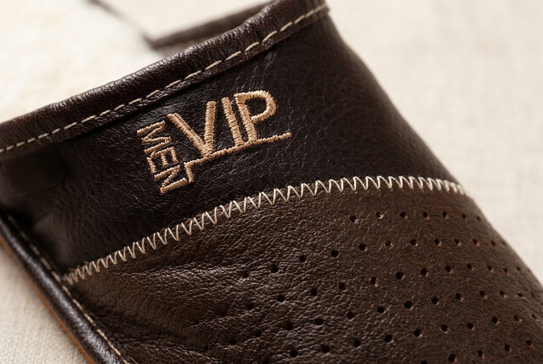 Vyšitý nápis VIP MEN zlatou nití na pruhu přes nárt, vedle děrovaná špička