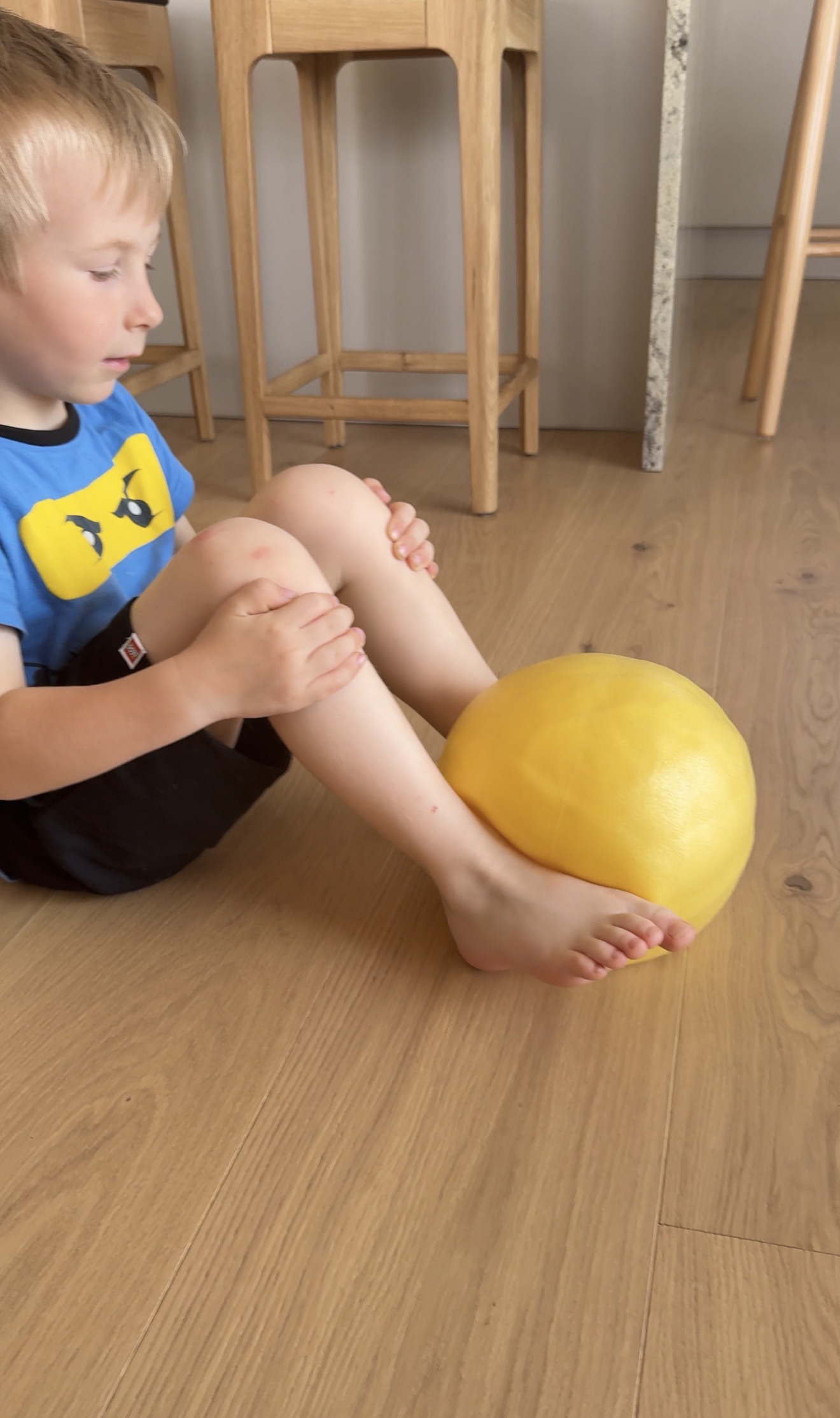 Dieťa pri domácej pohybovej hre s loptou v sede