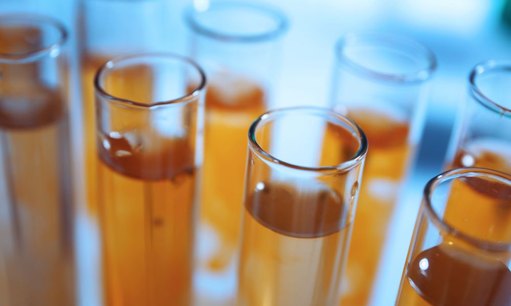 Testovanie vody – Kvapka vody padajúca z pipety do skúmavky počas laboratórnej analýzy.