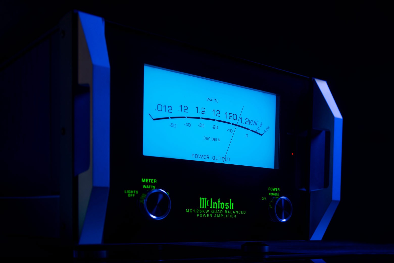 McIntosh MC1.25KW zepředu s rozsvíceným modrým wattmetrem na černém skleněném panelu