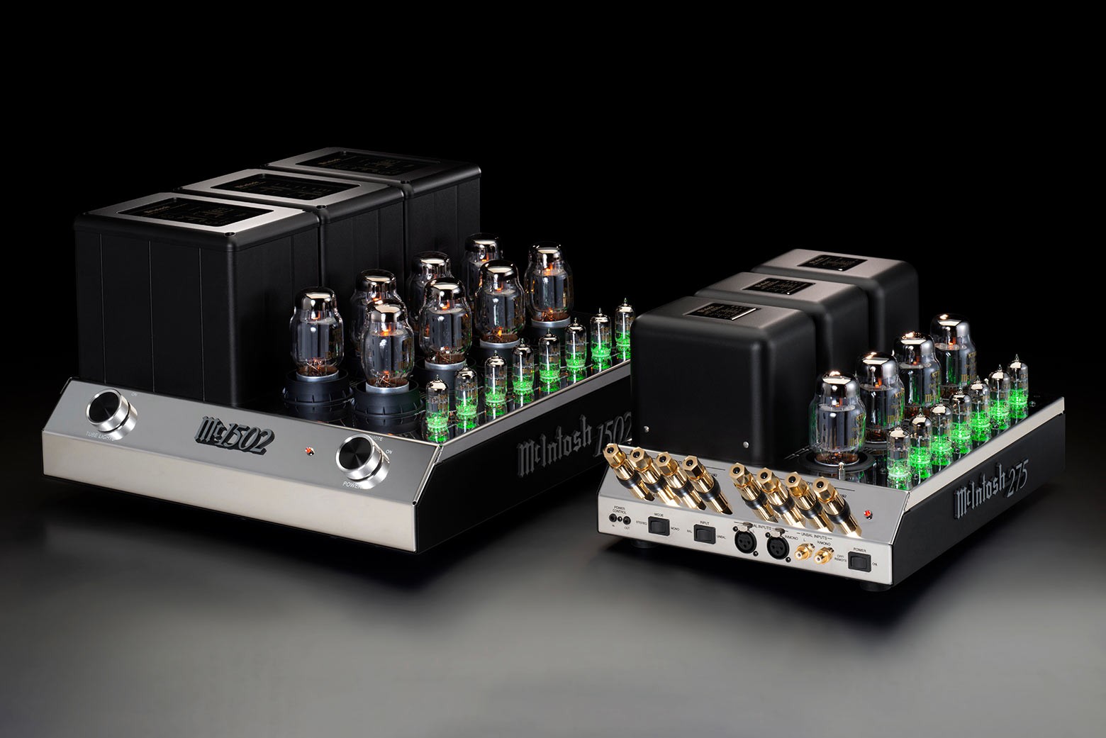 McIntosh MC1502 vlevo vedle menšího klasického modelu McIntosh MC275 vpravo, oba se zeleně svítícími elektronkami