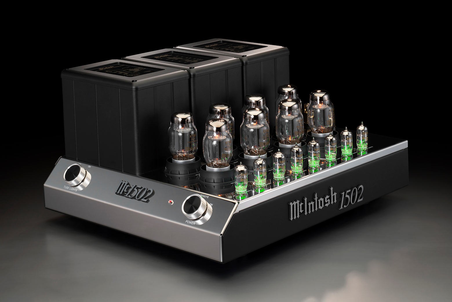 McIntosh MC1502 z levého úhlu, mirror-polished šasi se zeleně podsvícenými elektronkami a černými kryty transformátorů