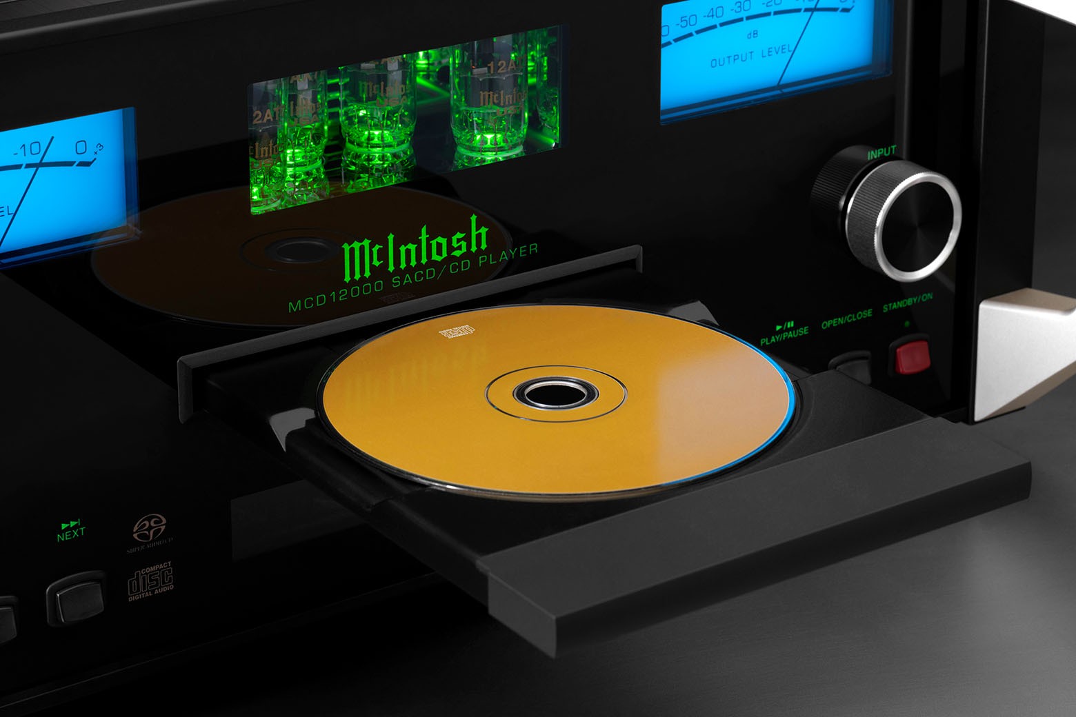 Detail otevřeného šuplíku McIntosh MCD12000 s vloženým SACD diskem a zeleně nasvícenými elektronkami za skleněným panelem