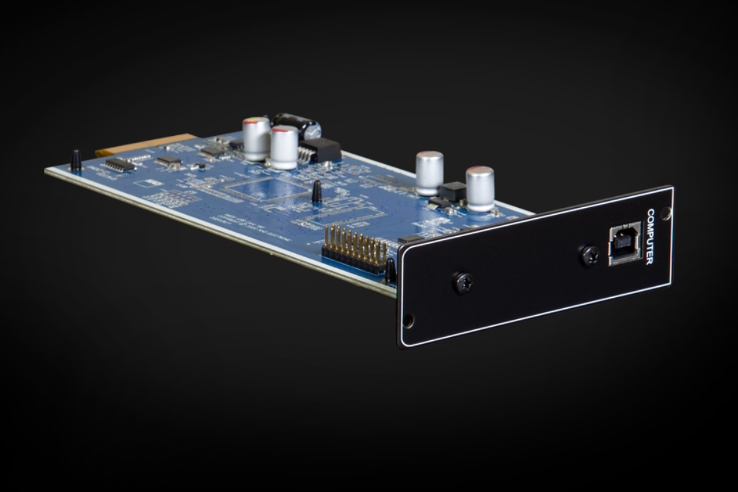 Modul NAD MDC USB DSD z boku — modrá deska plošného spoje s kondenzátory, zlacené konektory a černý čelní panel s USB portem na tmavém pozadí
