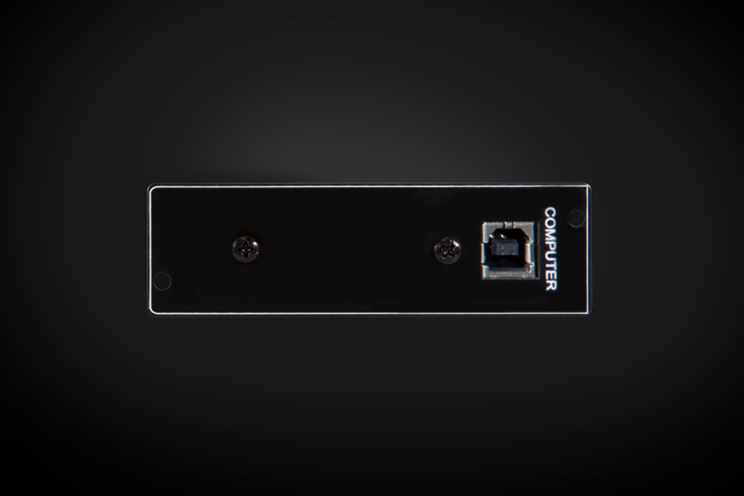 Detail černého čelního panelu modulu NAD MDC USB DSD s portem USB typu B s popiskem COMPUTER a dvěma montážními šrouby