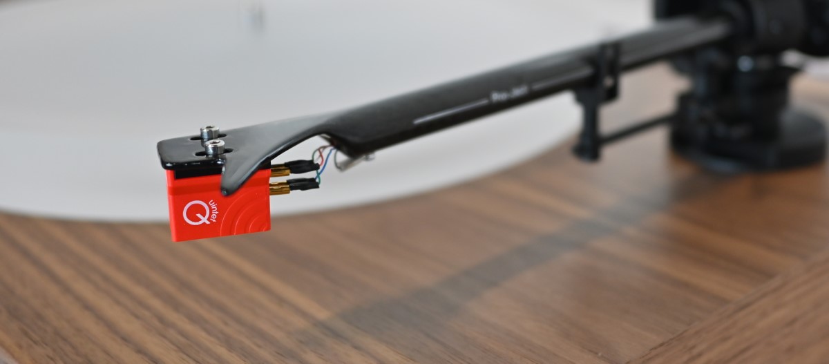 Detail MC přenosky Ortofon Quintet Red na uhlíkovém rameni Pro-Ject X2 B nad deskou