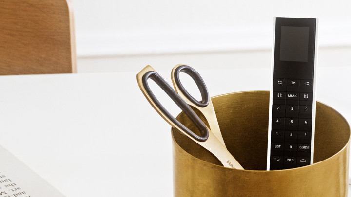 Bang & Olufsen Beoremote One v provedení Silver — lifestyle scéna na pracovním stole v designovém interiéru