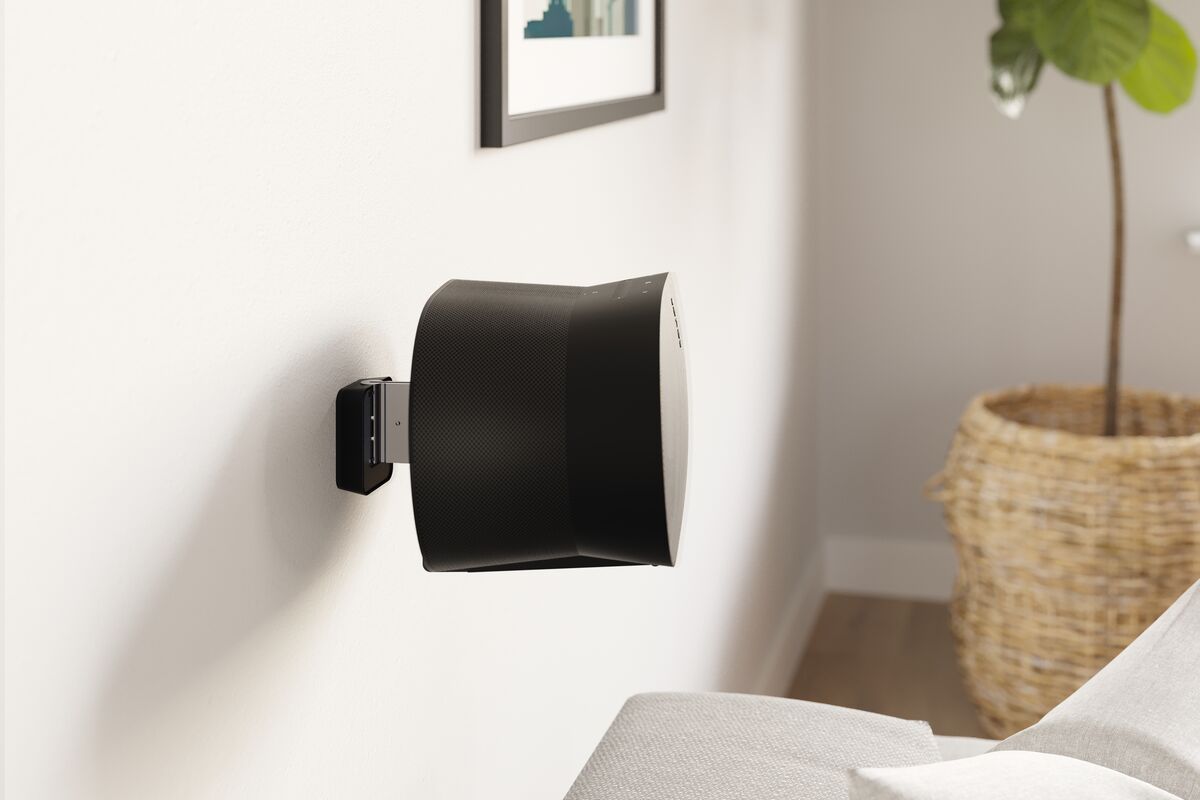 Černý reproduktor Sonos Era 300 zavěšený na černém nástěnném držáku Vogel's SWM 4131 v obývacím pokoji u pohovky