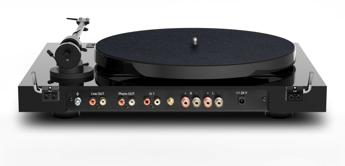 Pro-Ject JukeBox E1 HiFi Set na komodě s vinylovými deskami nad ním, akrylový protiprachový kryt a dálkové ovládání