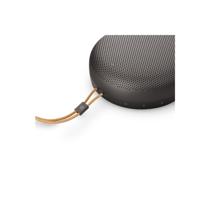 Bang & Olufsen Beosound A1 3rd Gen v provedení Warm Granite — detail těla a kožené poutko